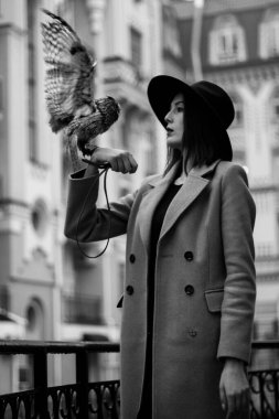 very beautiful girl in a hat with an owl. High quality photo