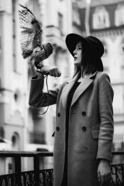 very beautiful girl in a hat with an owl. High quality photo