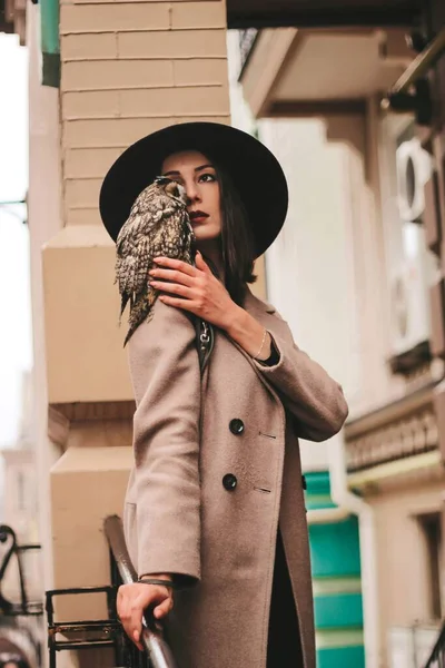 very beautiful girl in a hat with an owl. High quality photo