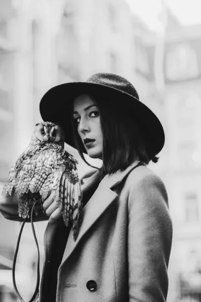 very beautiful girl in a hat with an owl. High quality photo