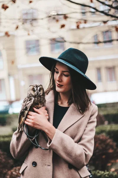 very beautiful girl in a hat with an owl. High quality photo
