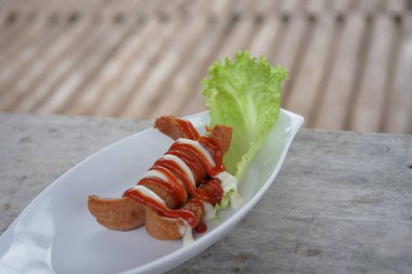 Sosisli, mayonez ve soslu beyaz tabak.