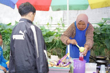 Yolun kenarında satış yapan bir kadın.