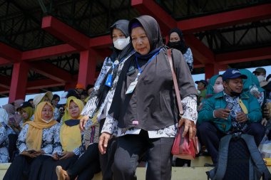 Endonezyalı devlet memurları stadyumda toplanıyor.