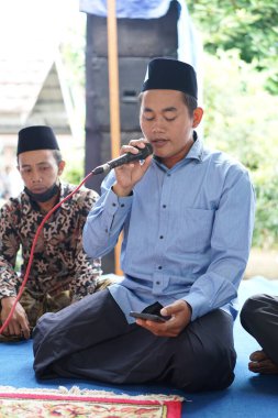 Dua etmek için mikrofon tutan bir adam