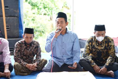 Dua etmek için mikrofon tutan bir adam