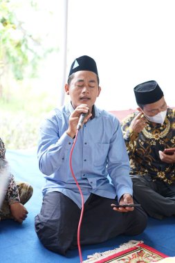 Dua etmek için mikrofon tutan bir adam