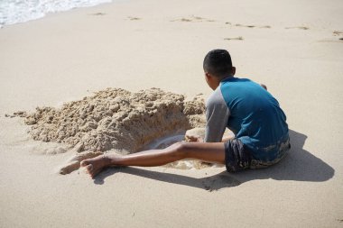 kum plaj oynayan bir boy