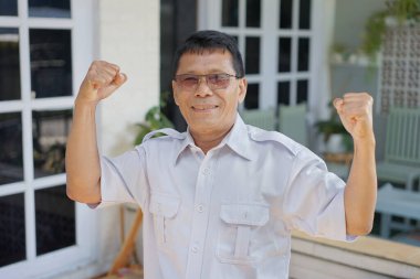 The man in white raises both fists
