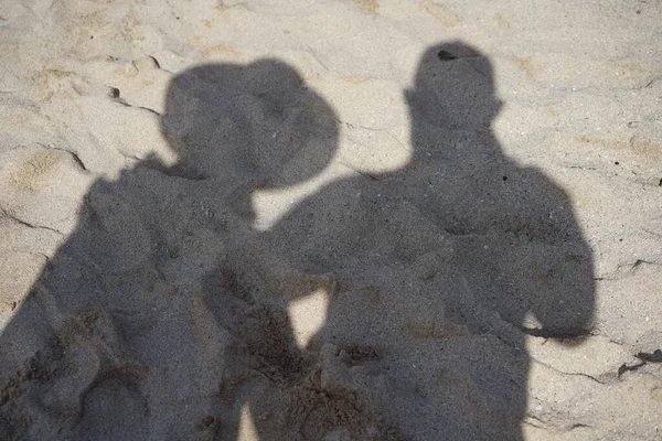 Shadow of two people on the sea sand
