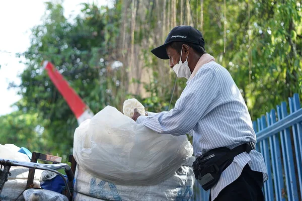 An old man is selling crackers on the side of the road
