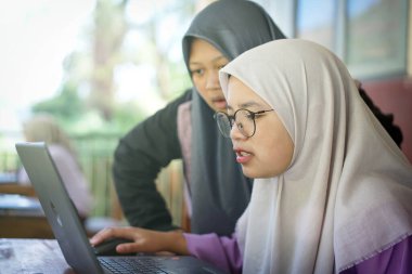 Indonesian junior high school students study online using chromebook laptops