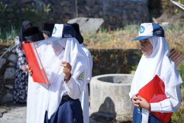 Indonesian junior high school students reading the text during the ceremony