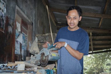 A woodcutter operating a cutting tool