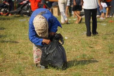 Yaşlı kadın omuzunda mavi bir çuval taşıyordu.