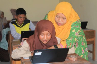 Indonesian junior high school students study online using chromebook laptops