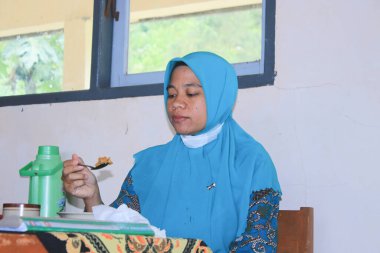 Endonezya öğretmeni ofiste mola veriyor.