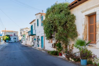 Larnaca Cyrpus 'taki eski antik binalar. Küçük çiçekli yeşil çalılar. Yaz mevsimi boyunca güneşli bir gün ve mavi bir gökyüzü. Güzel kapılar ve pencereler.