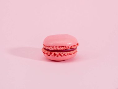 Pembe arka planda duran pembe badem kurabiyesi.