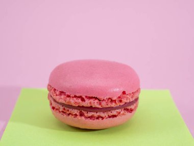 Pembe arka planda duran pembe badem kurabiyesi.