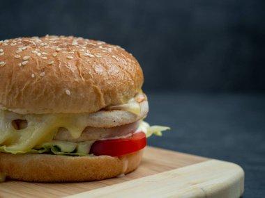 Salatalı sığır burger, siyah ahşap bir masanın üzerinde peynir..