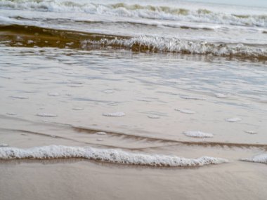Beyaz köpüklü sahil kıyısı dalgası. Kumsal kıyısı.