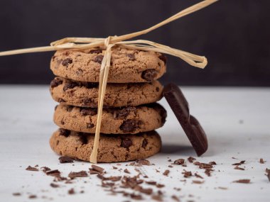 Beyaz ahşap arka planda çikolata parçacıklı kurabiyeler..