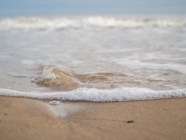 Beyaz köpüklü sahil kıyısı dalgası. Kumsal kıyısı.