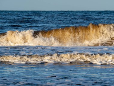 Beyaz köpüklü sahil kıyısı dalgası. Kumsal kıyısı.
