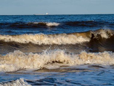 Beyaz köpüklü sahil kıyısı dalgası. Kumsal kıyısı.