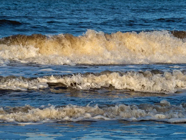 Beyaz köpüklü sahil kıyısı dalgası. Kumsal kıyısı.