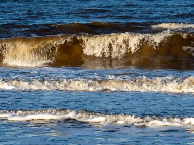 Beyaz köpüklü sahil kıyısı dalgası. Kumsal kıyısı.
