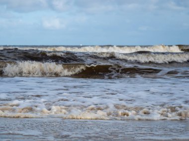Beyaz köpüklü sahil kıyısı dalgası. Kumsal kıyısı.