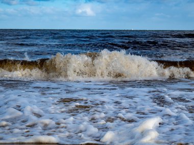 Beyaz köpüklü sahil kıyısı dalgası. Kumsal kıyısı.