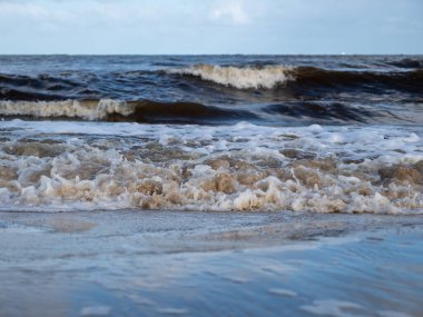 Beyaz köpüklü sahil kıyısı dalgası. Kumsal kıyısı.