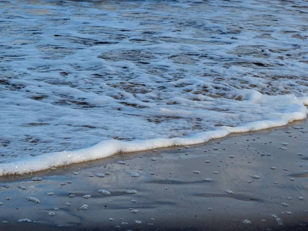 Onda con spiaggia bianca di costa schiumosa. Riva sabbiosa. — Foto Stock