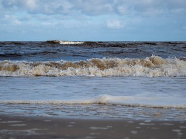 Beyaz köpüklü sahil kıyısı dalgası. Kumsal kıyısı.