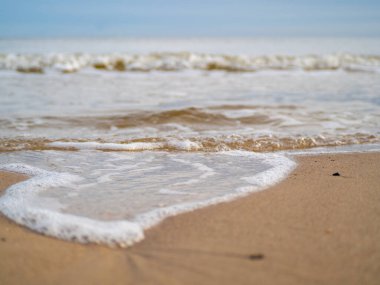Beyaz köpüklü sahil kıyısı dalgası. Kumsal kıyısı.