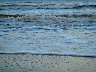 Beyaz köpüklü sahil kıyısı dalgası. Kumsal kıyısı.