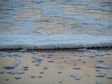 Beyaz köpüklü sahil kıyısı dalgası. Kumsal kıyısı.