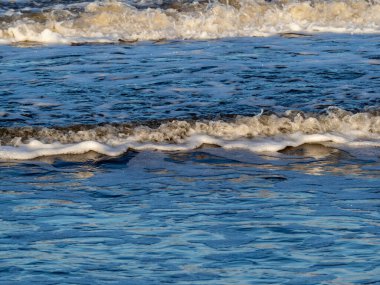 Beyaz köpüklü sahil kıyısı dalgası. Kumsal kıyısı.