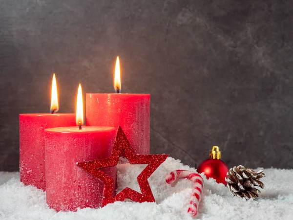 红色圣诞蜡烛和灰色背景的圣诞装饰品. — 图库照片