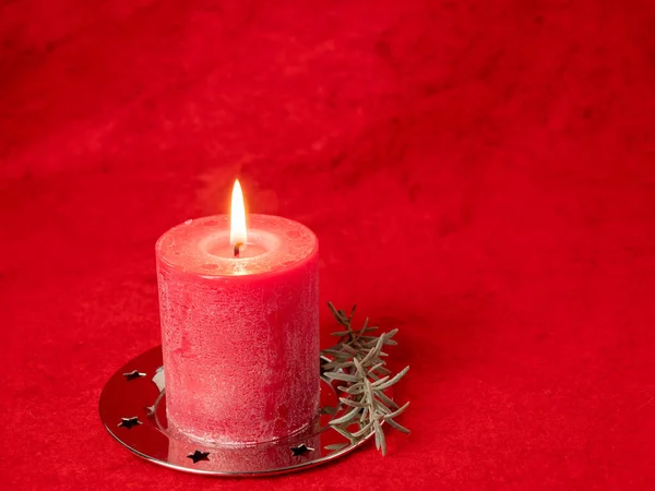 Red Christmas candle and Christmas decorations on a red background. — Stock Photo, Image