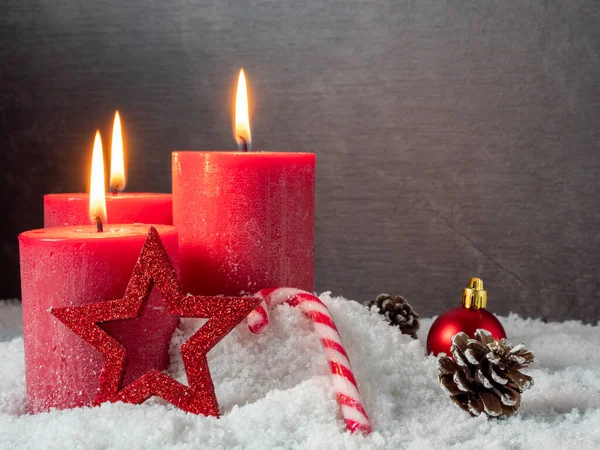 红色圣诞蜡烛和灰色背景的圣诞装饰品. — 图库照片