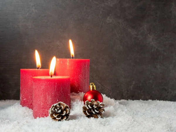 Красная рождественская свеча и рождественские украшения на сером фоне. — стоковое фото