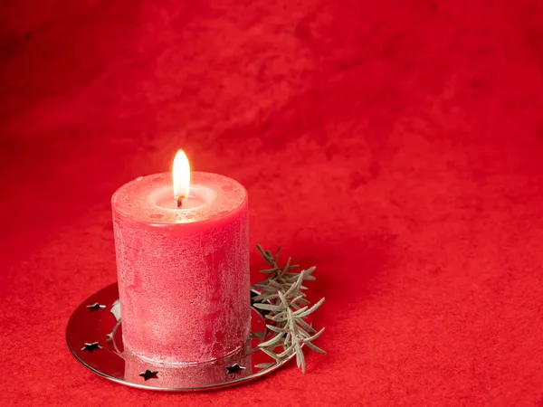 Red Christmas candle and Christmas decorations on a red background. — Stock Photo, Image