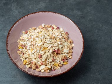 Muesli in a cup on a gray table.