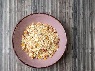 Muesli in a cup on a wooden table. Muesli on a wooden background.