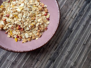 Muesli in a cup on a wooden table. Muesli on a wooden background.