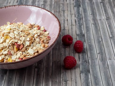 Muesli in a cup on a wooden table. Muesli on a wooden background.
